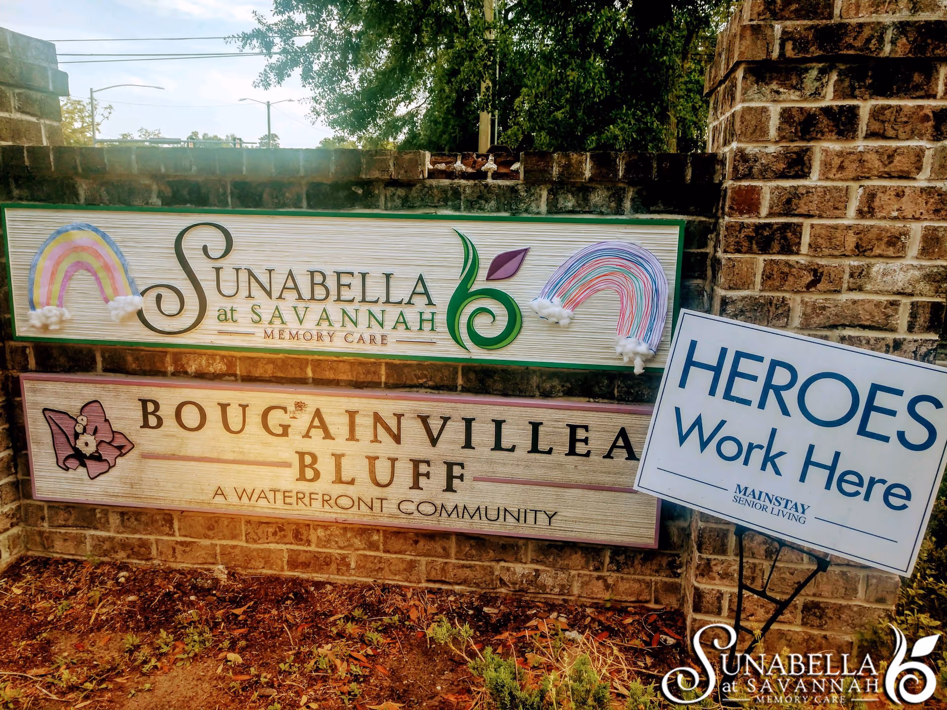 Outdoor brick entrance features Sunabella at Savannah sign and Heroes Work Here board.