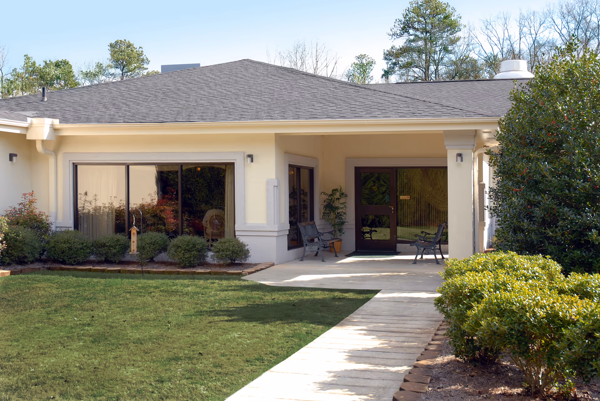 Front view of Life Care Center of Gwinnett entrance with covered porch and seating.