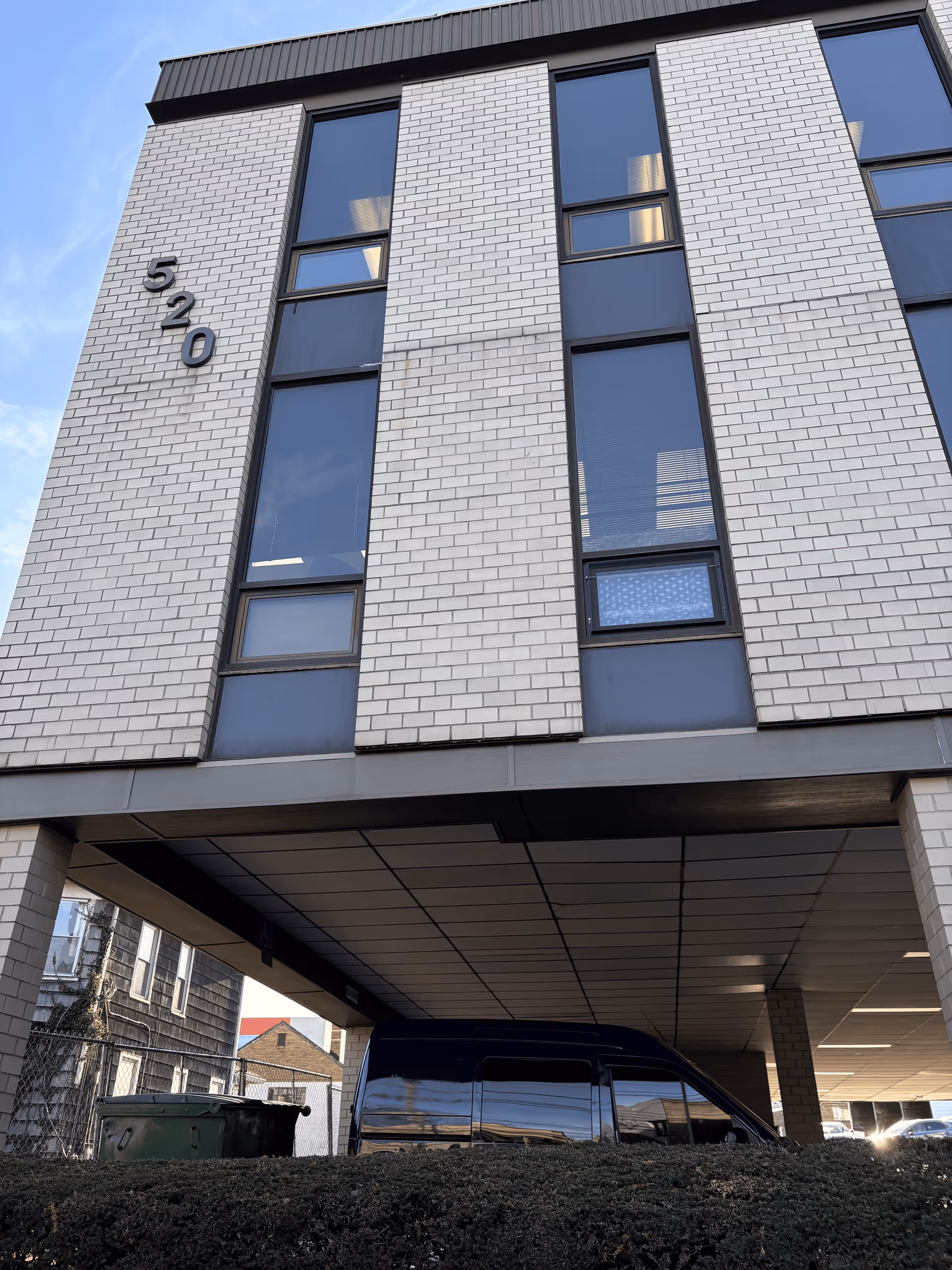 Modern brick building facade with large windows and a covered entrance