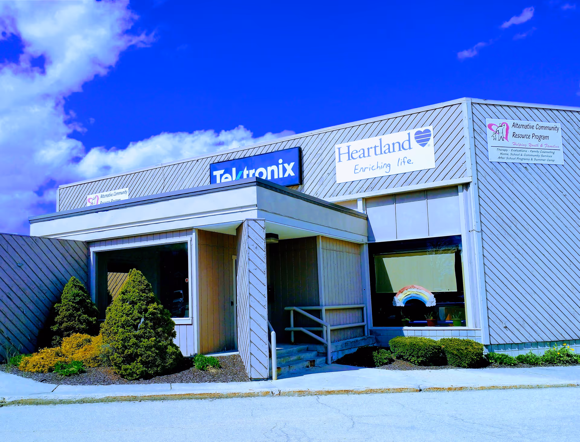 Exterior view of Heartland Hospice building with signage and landscaped shrubs.