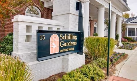 Exterior view of Schilling Gardens assisted living with sign, brick building, and columns.