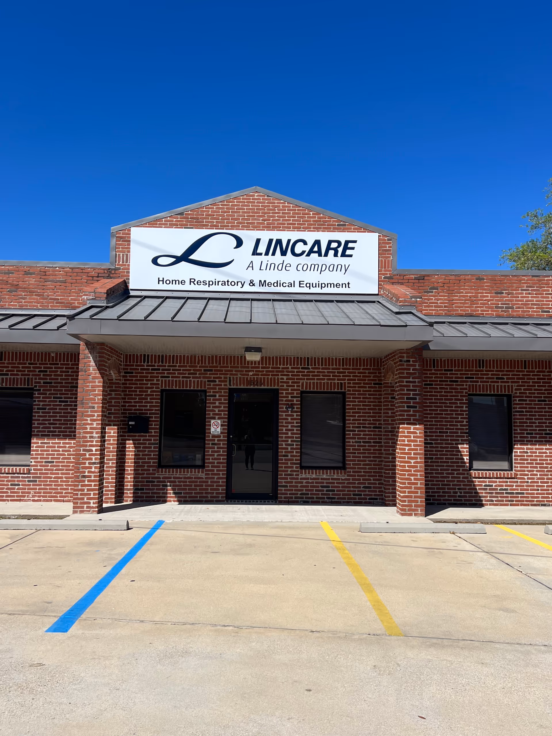 Brick storefront of LINCARE homecare with a large sign and parking lot.