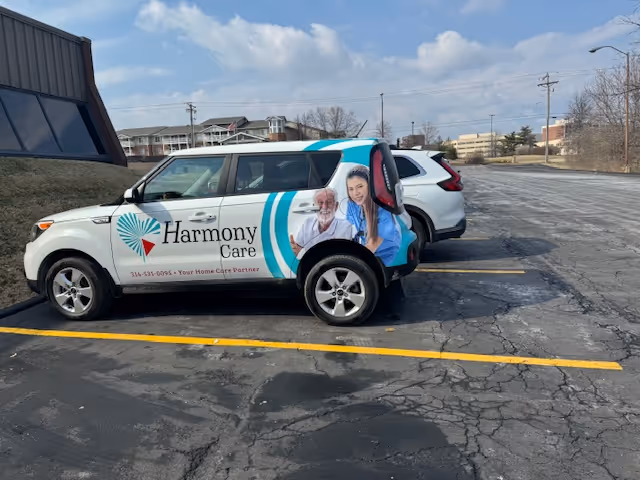 Harmony Care Illinois LLC van with caregiver artwork in a parking lot.