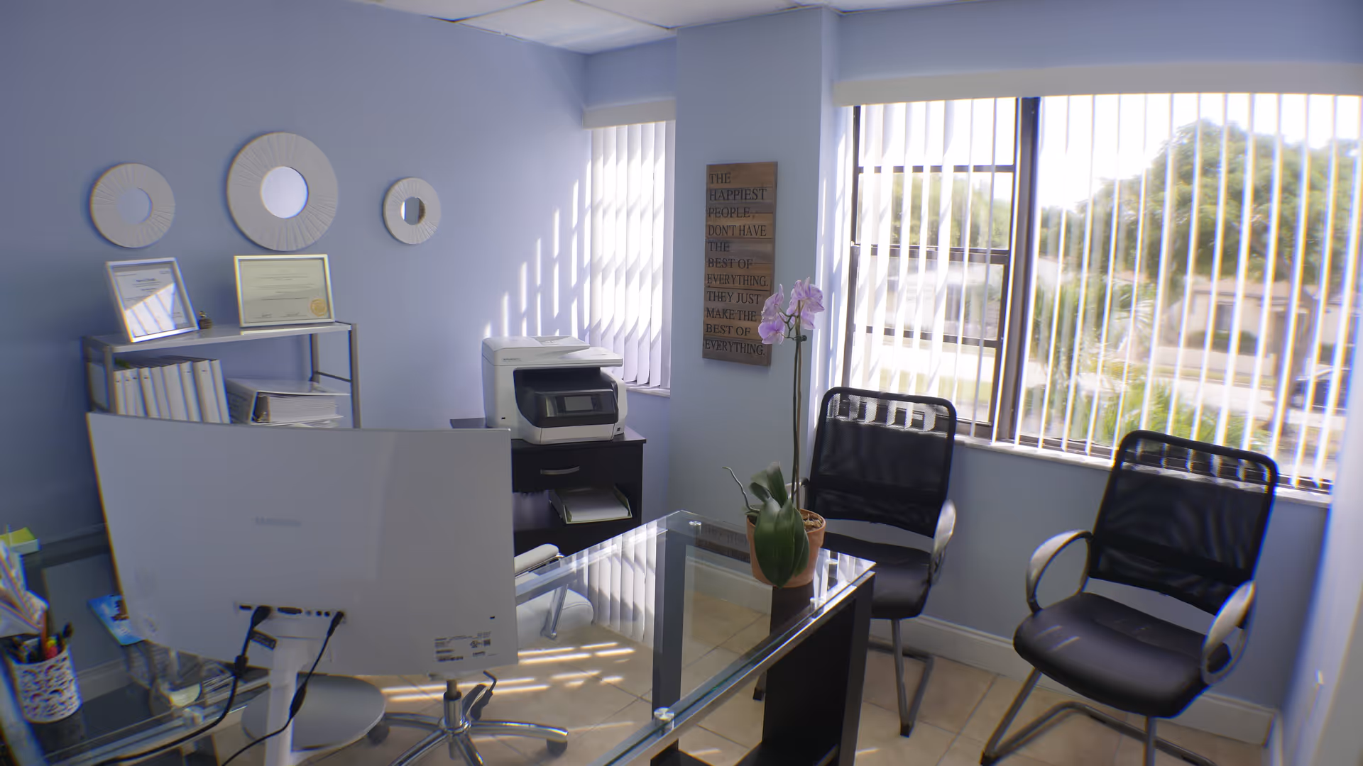 Office reception area with desk, computer, printer, and two chairs.