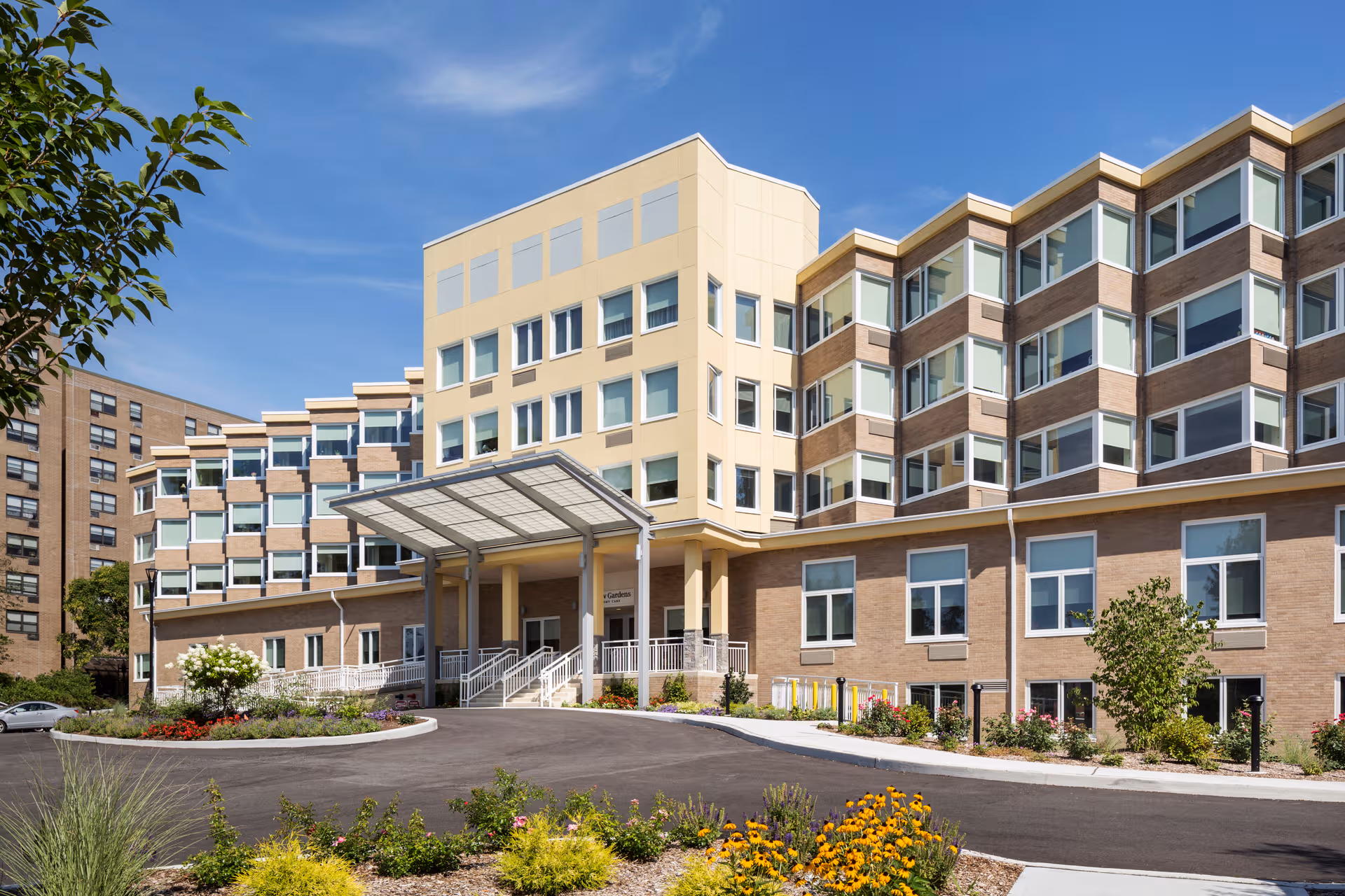 Willow Gardens Memory Care exterior: a modern multi-story building with a covered entrance and landscaping.