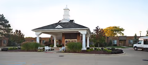 Front entrance of Rivergate Health Care Center with white columns and a covered portico.