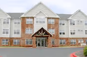 Exterior view of Sunnybrook Senior building with brick entrance and glass doors.
