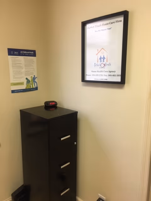 Corner hallway with a black three-drawer cabinet, wall posters, and a digital clock.