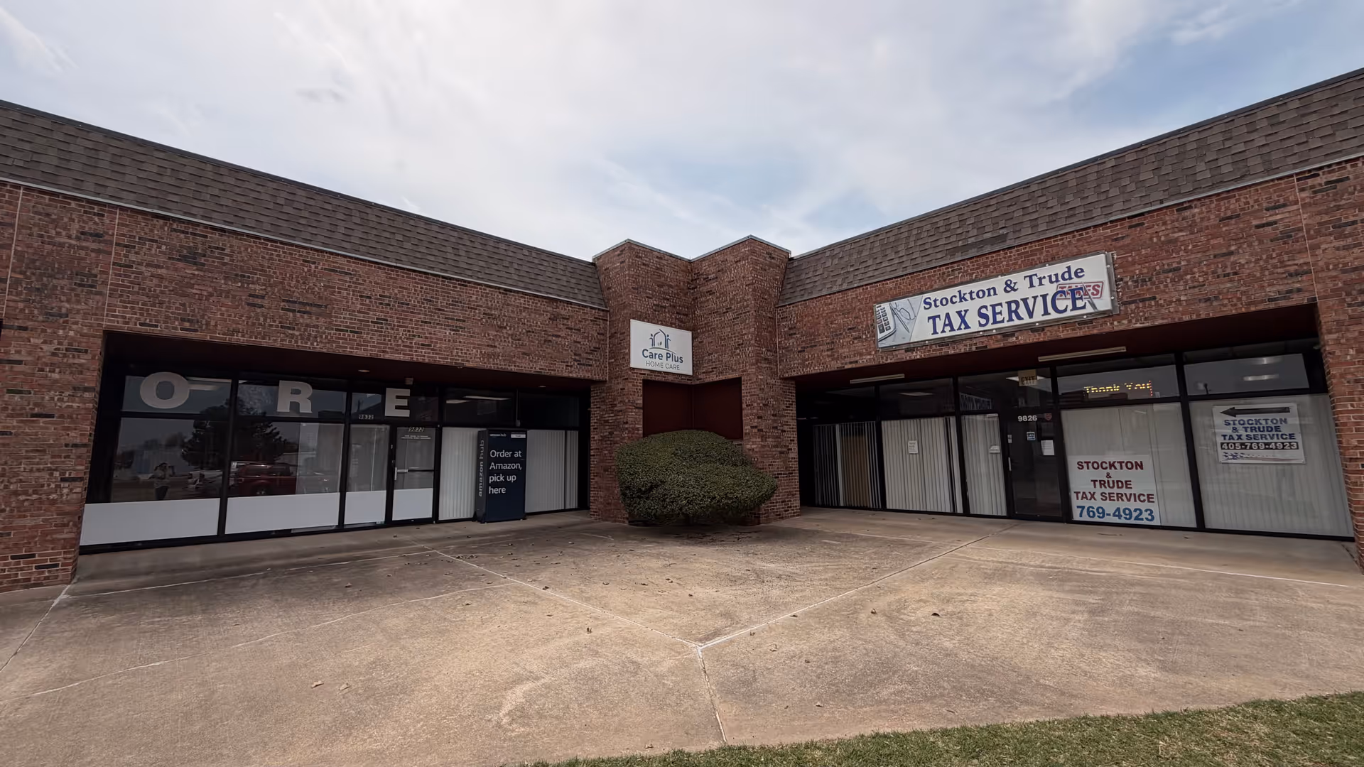 Exterior view of a brick storefront complex with a Care Plus Home Care sign.