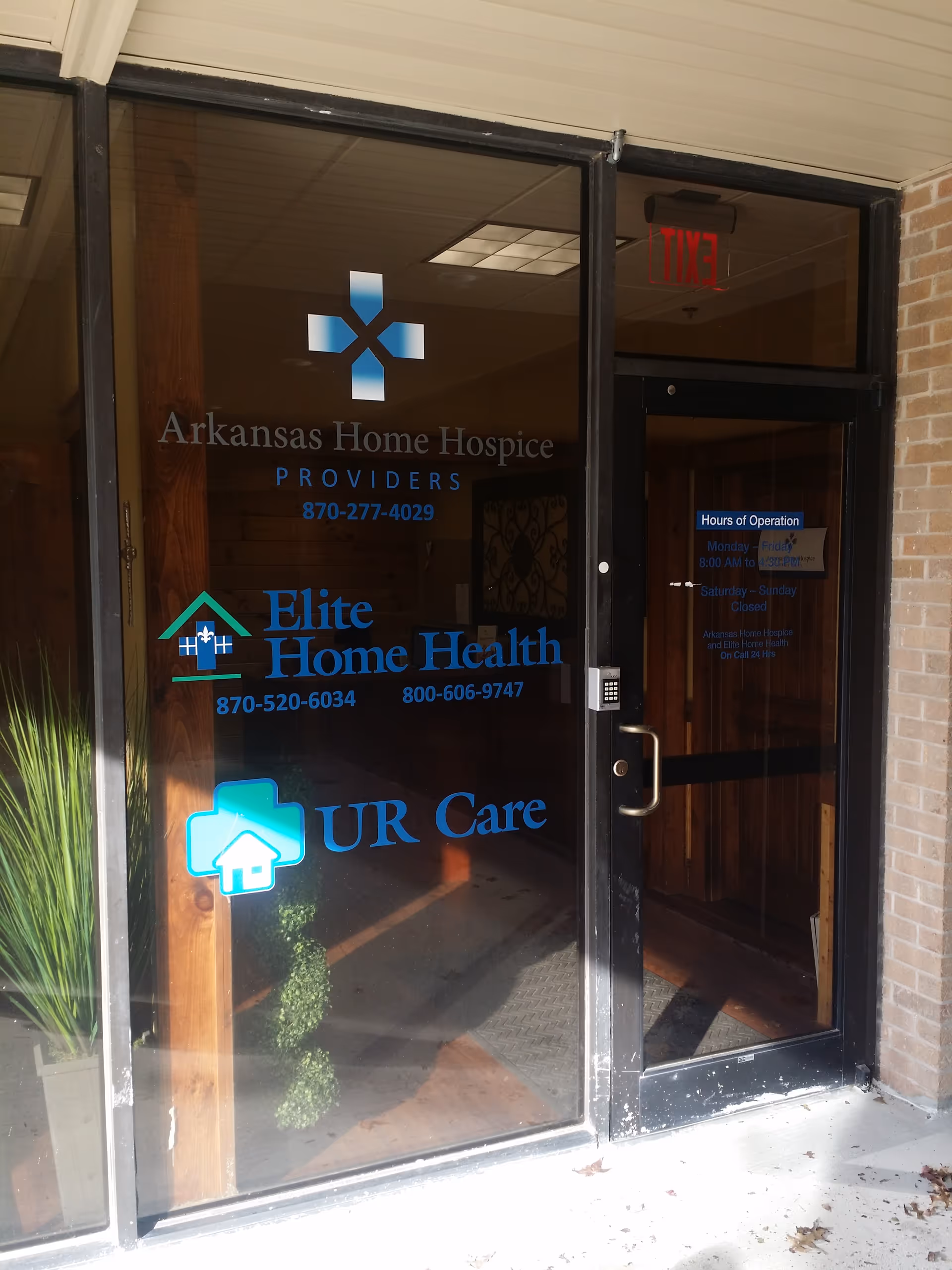 Glass entrance door of Elite Home Health of Jonesboro with Arkansas Home Hospice logos.