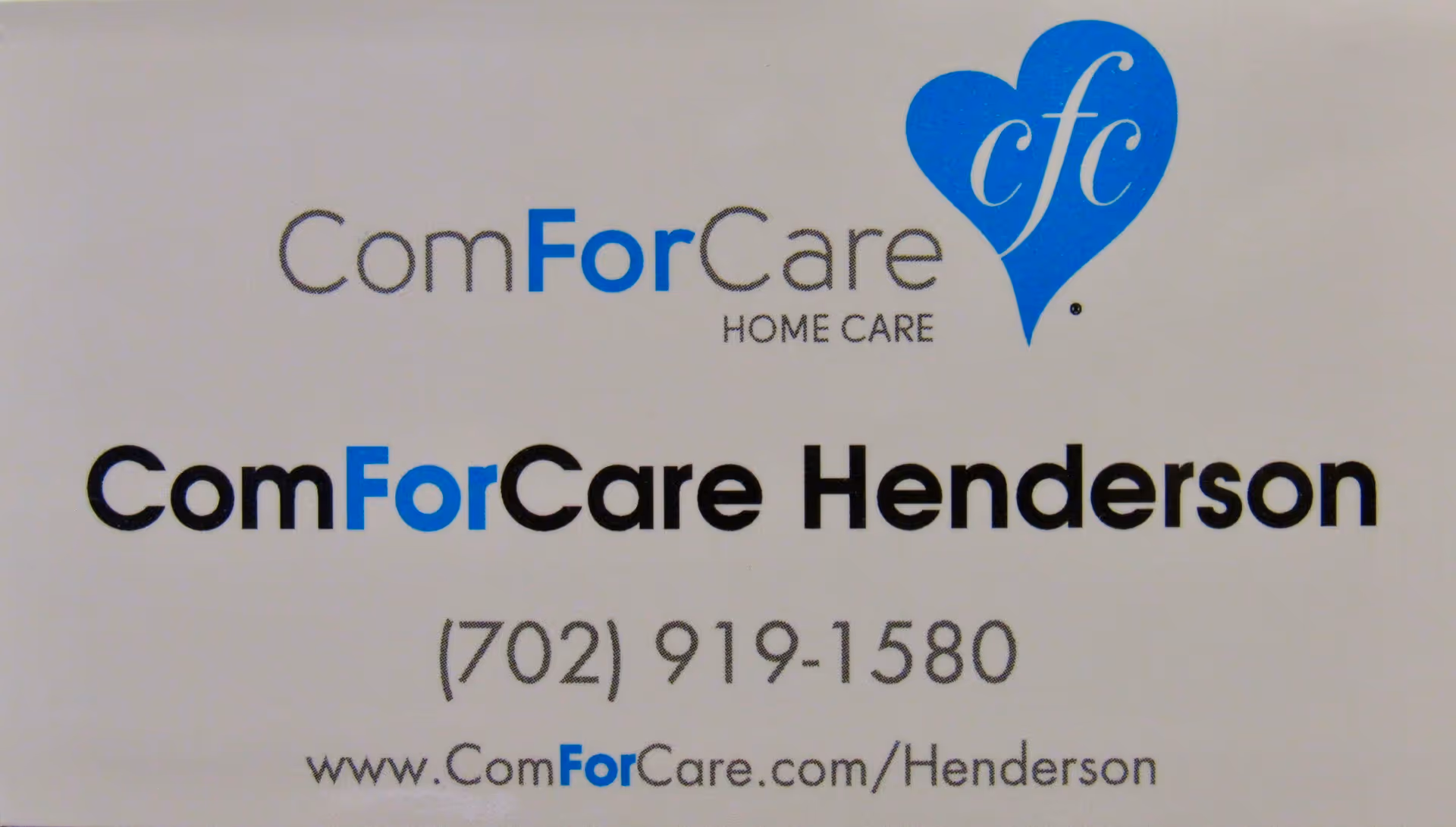 Close-up of ComForCare Henderson sign with blue heart logo on wall