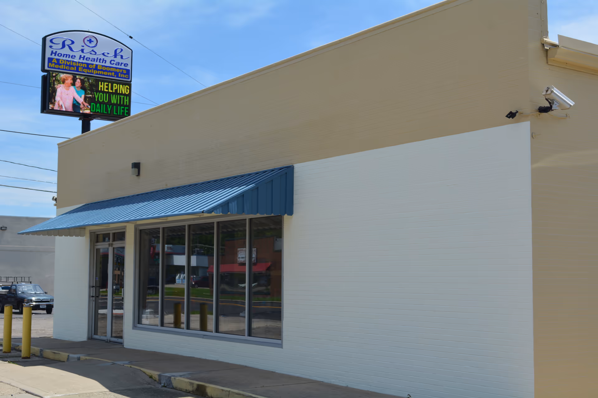 Beige building with blue awning and Risch Home Health Care sign on top.