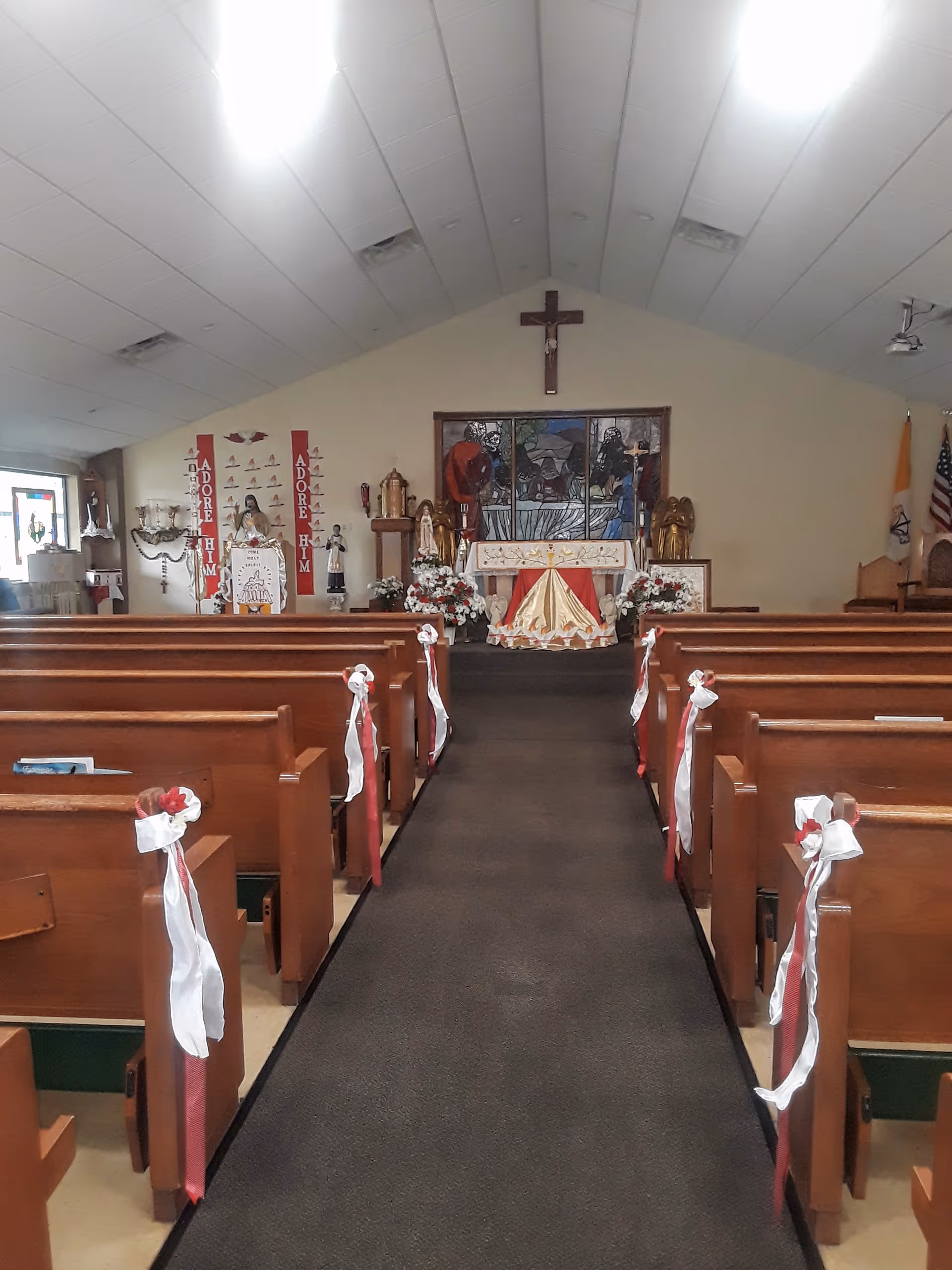 Interior of Blessed Sacrament Manor chapel with pews and stained-glass altar.