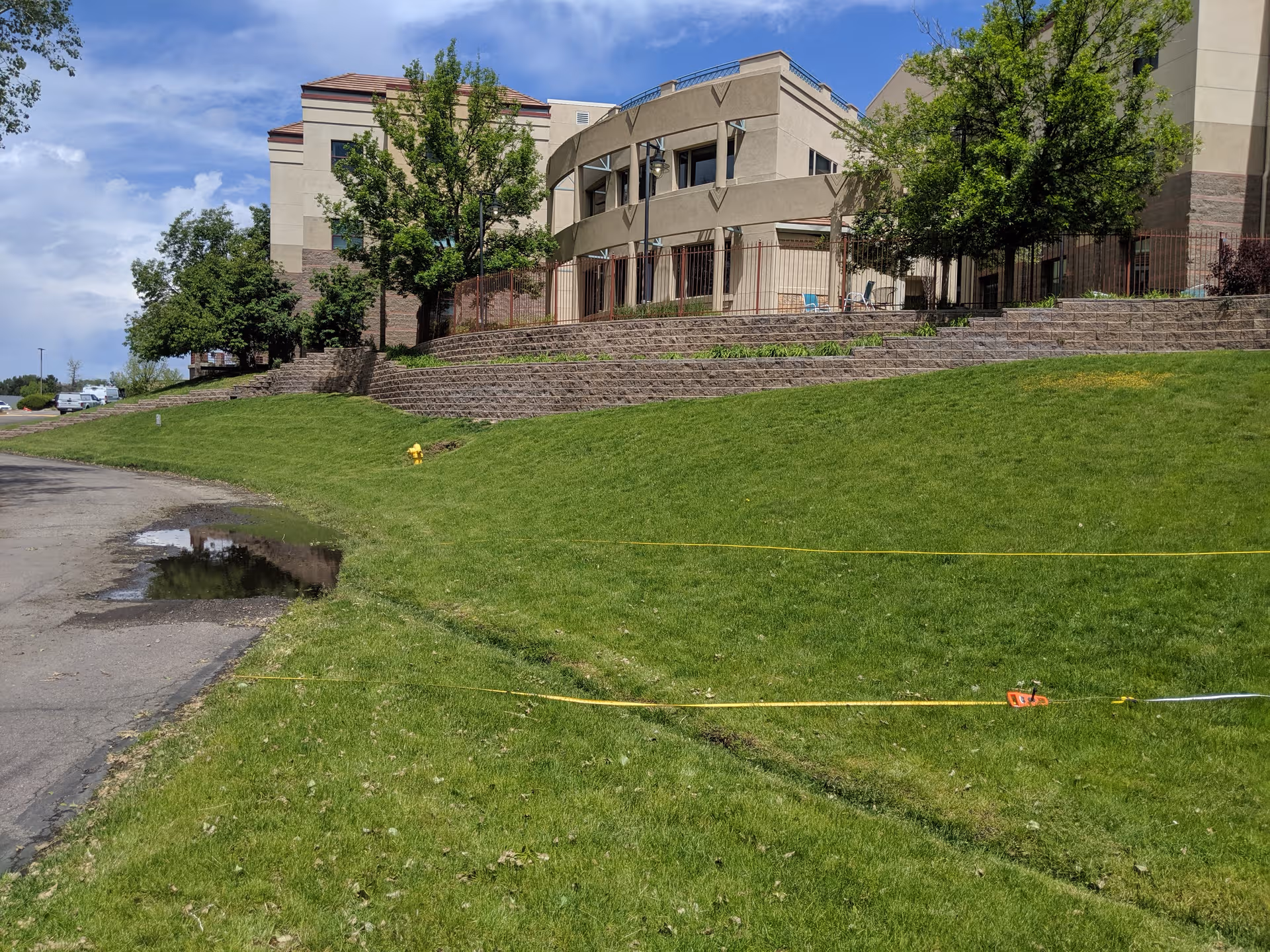 Shalom Park senior living facility exterior with grassy slope and steps.