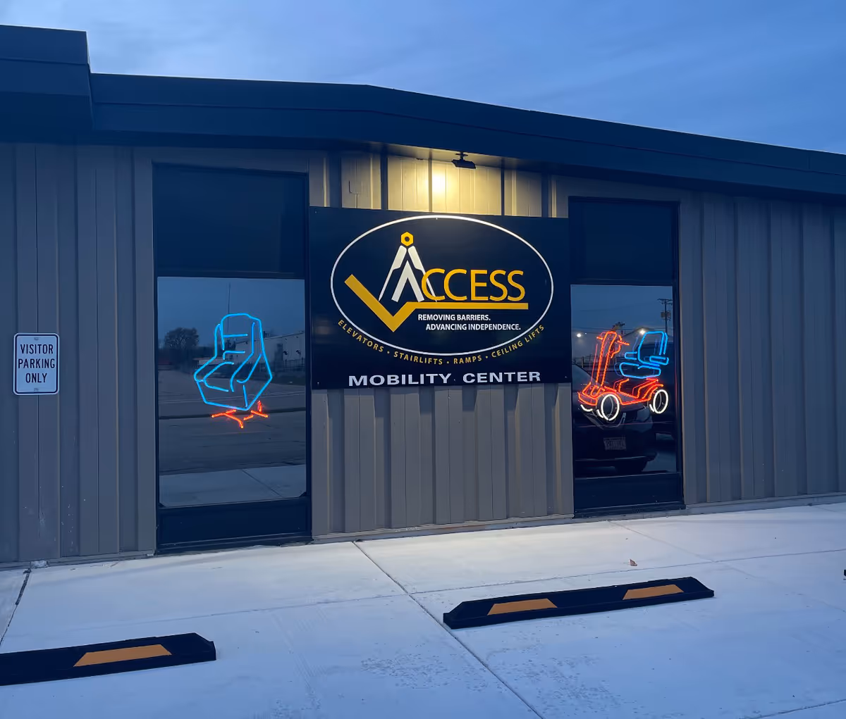 Exterior view of ACCESS Mobility Center building with large sign and neon window graphics.