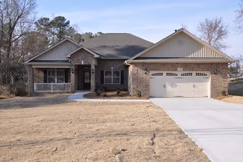Front view of a single-story building with brick accents and a two-car garage.