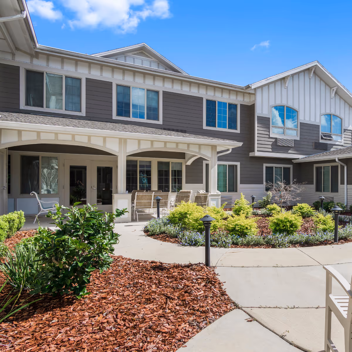 Exterior view of The Willows senior living facility with a covered patio and landscaped entrance