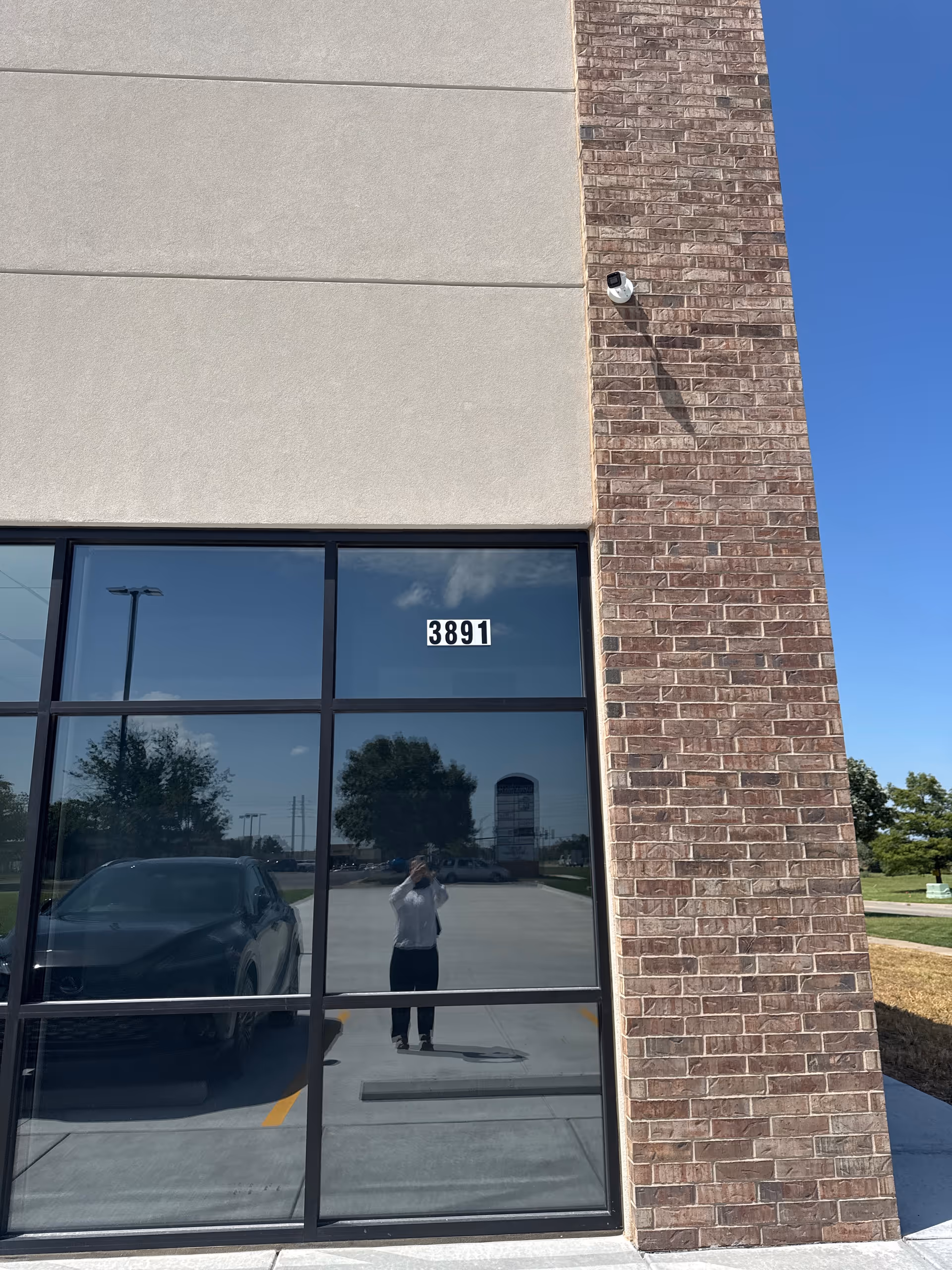 Exterior view of brick and glass facility facade with a security camera