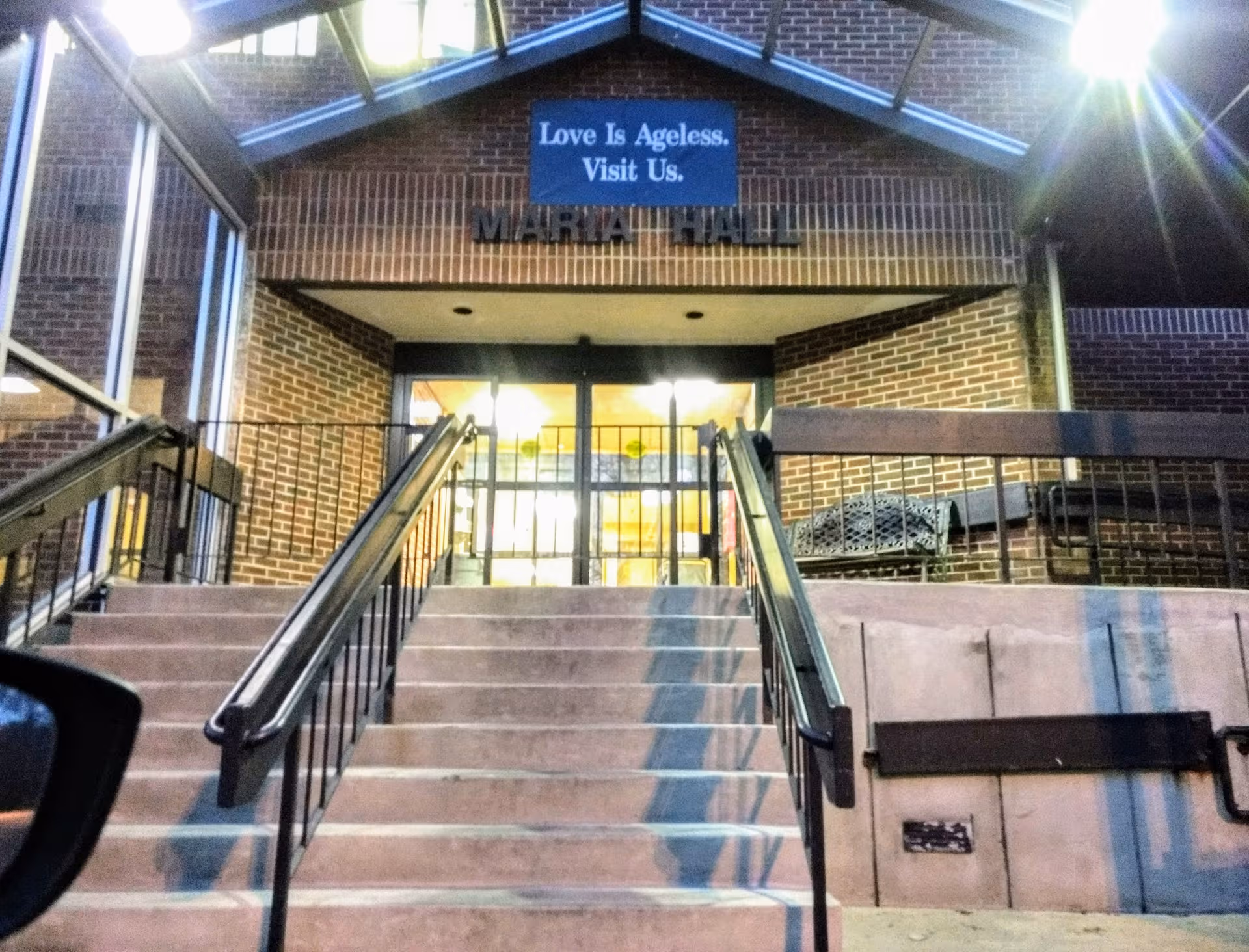 Brick exterior entrance to a senior care facility with stairs and glass doors
