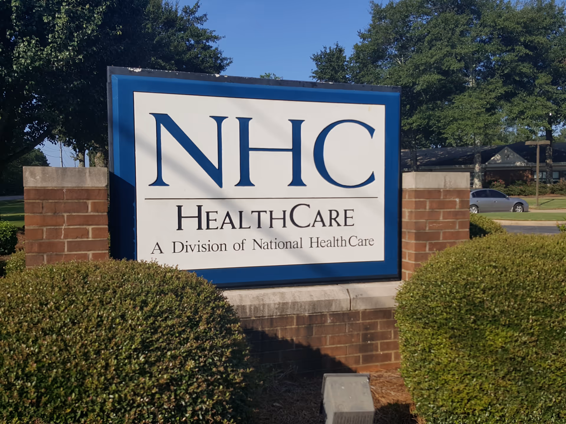 Exterior view of the NHC HealthCare North Augusta sign with brick planters.