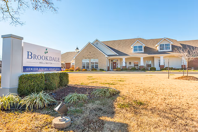 Exterior view of Brookdale Wellington senior living facility with sign and entrance.
