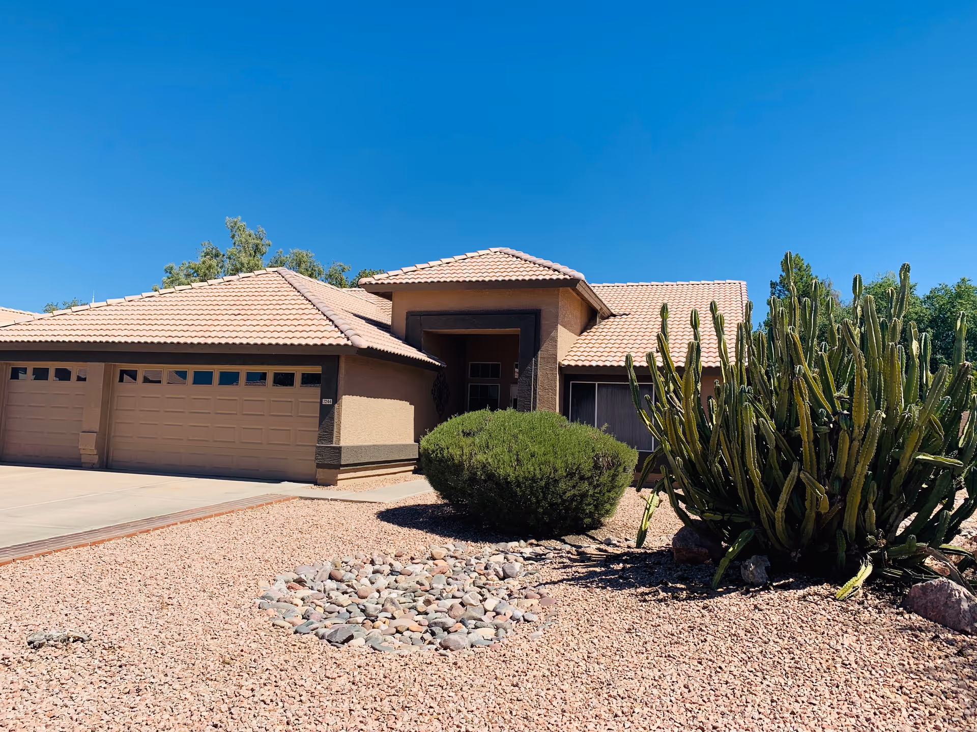 Front view of a single-story assisted living home with desert landscaping.