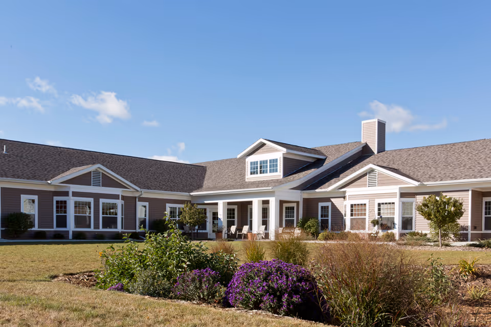 Single-story senior living facility exterior with a welcoming front entrance and manicured landscaping.