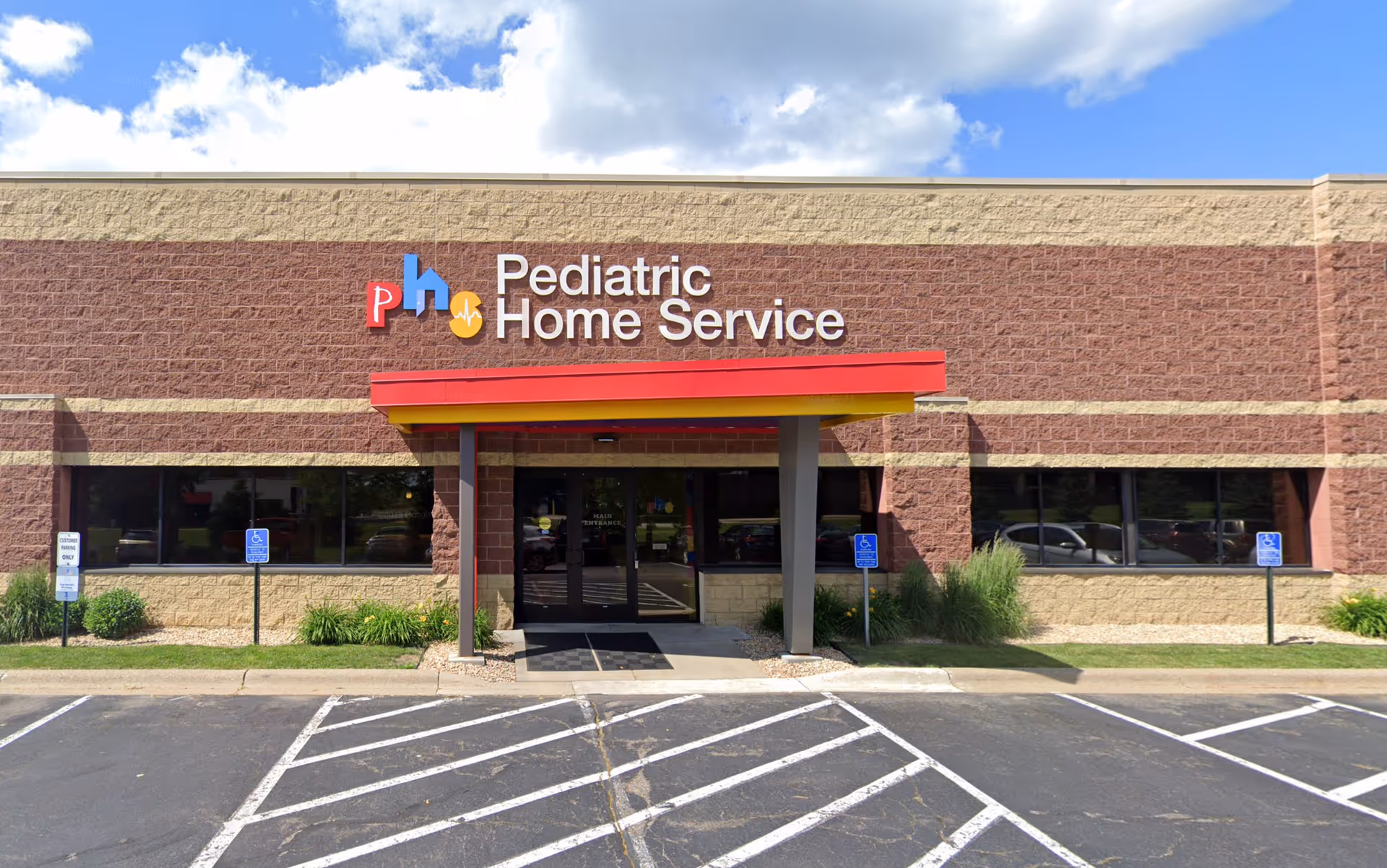 Brick office building exterior displaying the Pediatric Home Service sign and accessible entrance.