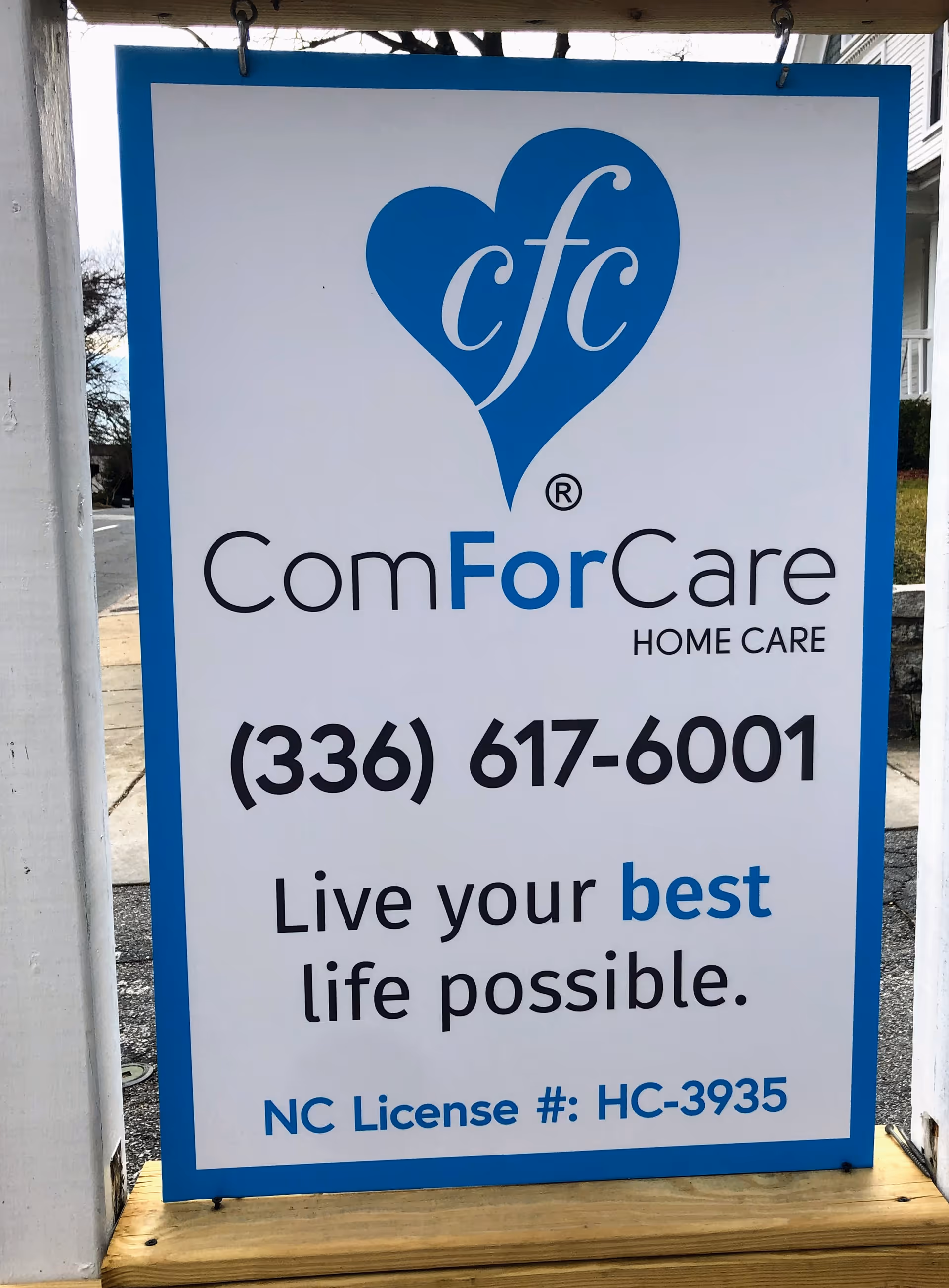 Outdoor ComForCare Home Care sign with logo, phone number, and slogan.