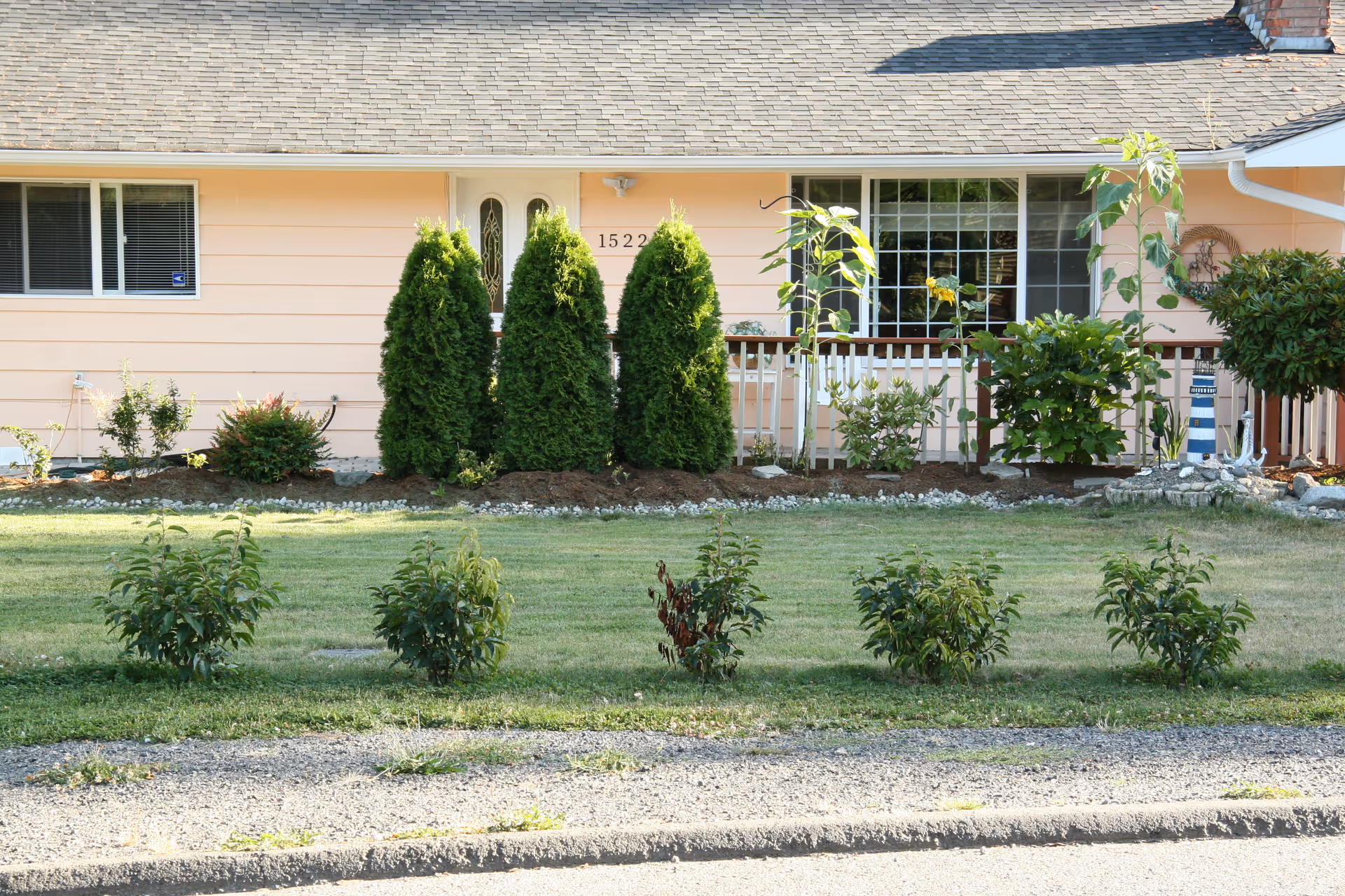 A peach-colored senior living facility with manicured lawn and shrubs in front.