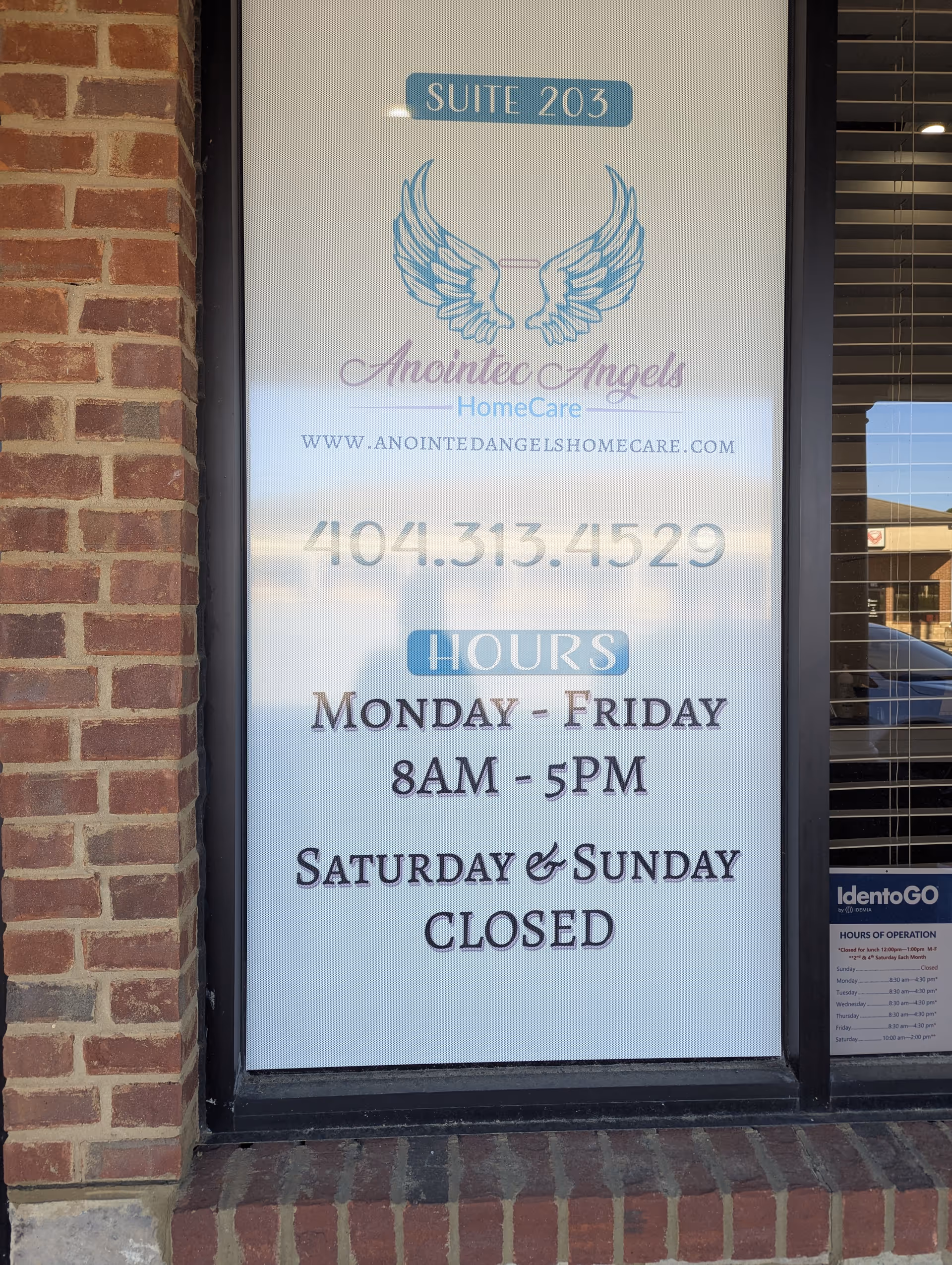 Front of building window sign for Anointed Angels HomeCare with hours and contact.