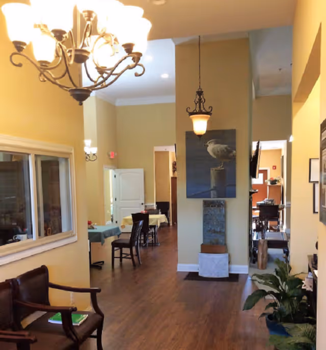 Spacious interior lobby with chandeliers, seating, and dining tables.