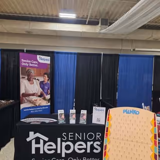 Indoor expo booth for Senior Helpers of Southeast Nebraska with banners and a Plinko-style game board.