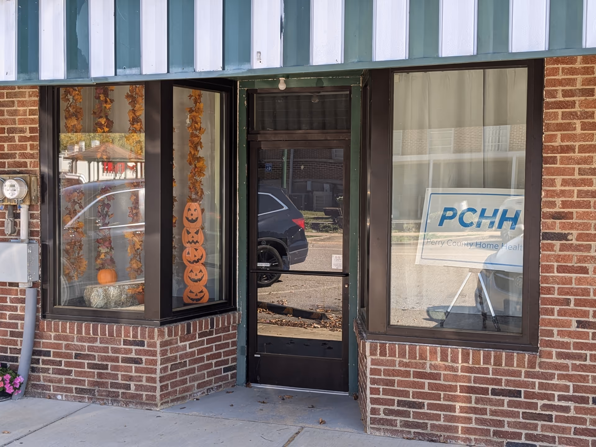Brick exterior of Perry County Home Health building with pumpkins decorating the front windows.