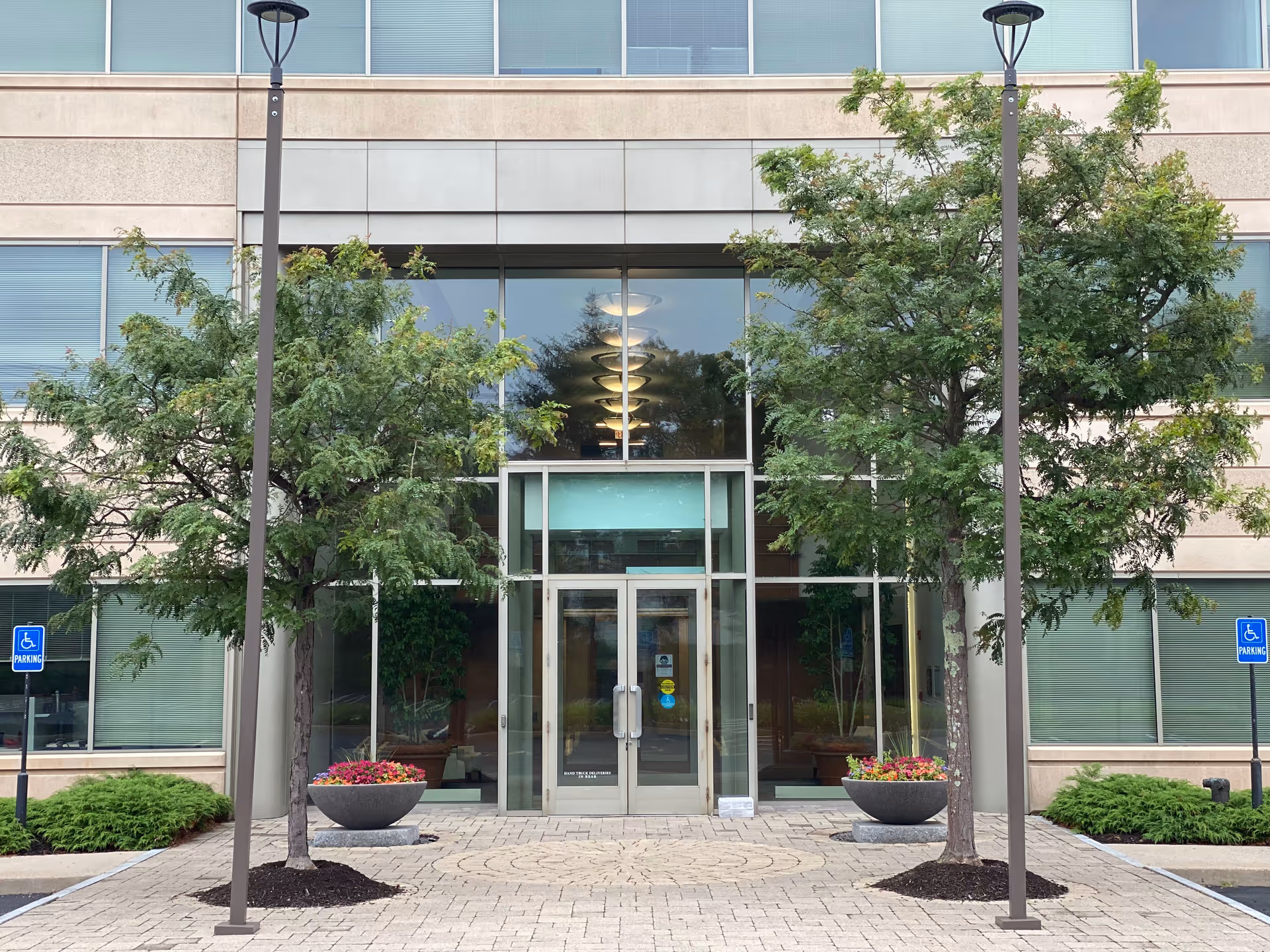 Exterior view of a building entrance with glass doors and landscaping.