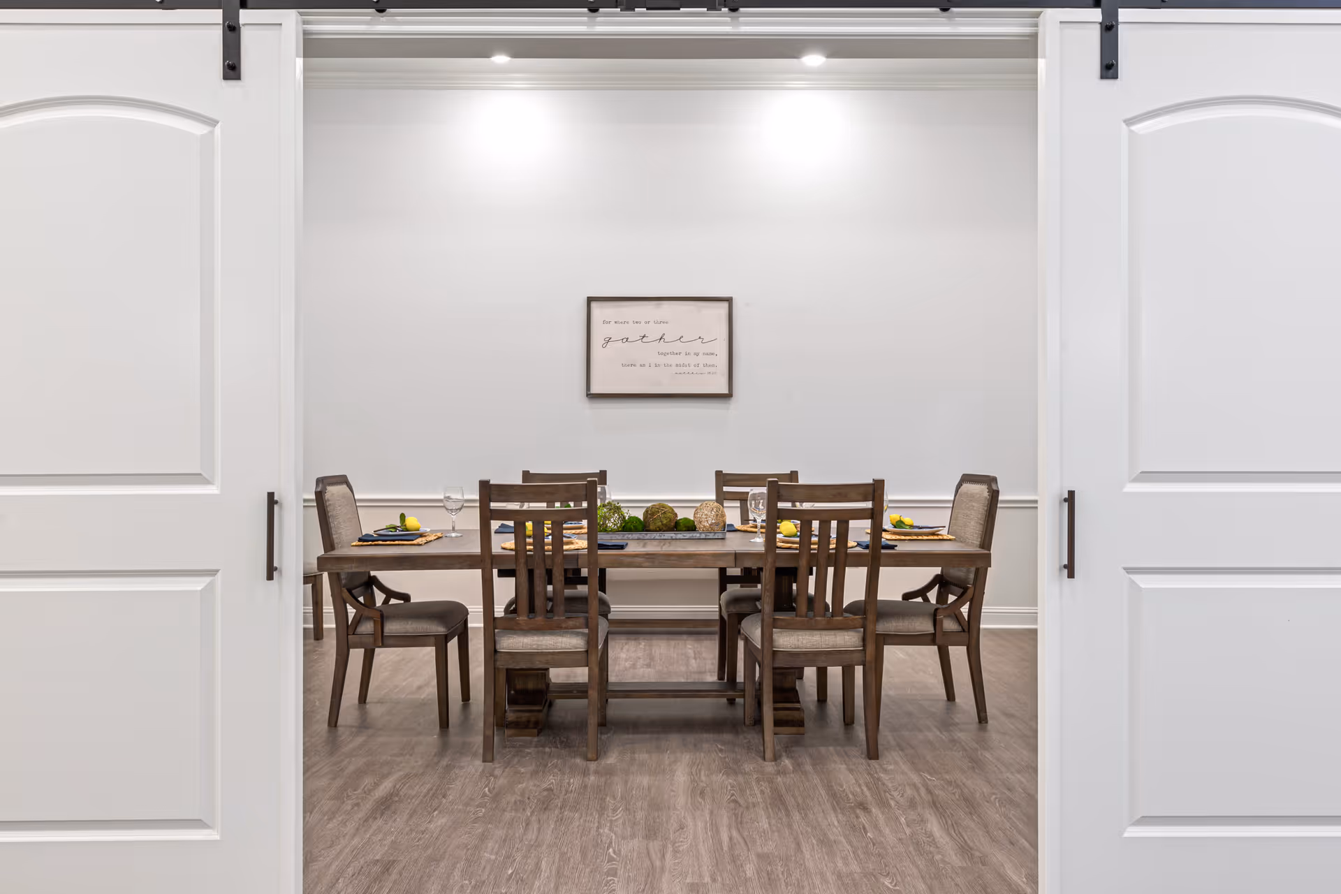 A dining room inside a senior living facility with a long wooden table and chairs.