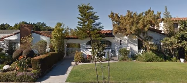 Front exterior of Westwood Manor showing manicured lawn, shrubs, and a walkway to the entrance.