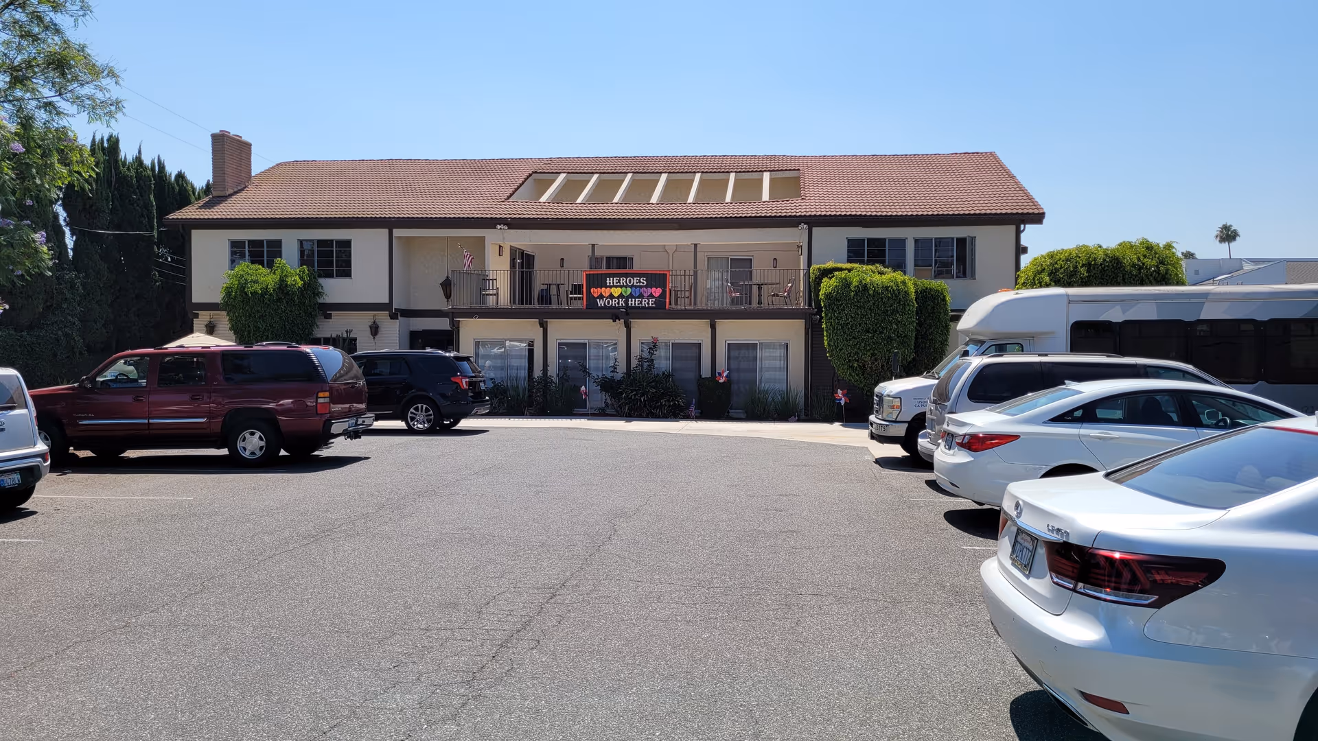 Whittier Glen Assisted Living exterior: two-story building with red-tiled roof, front entrance, and parked cars.
