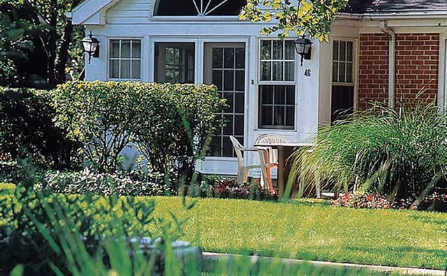 Front exterior of Westminster Place in Evanston with lawn, shrubs, and a patio table.