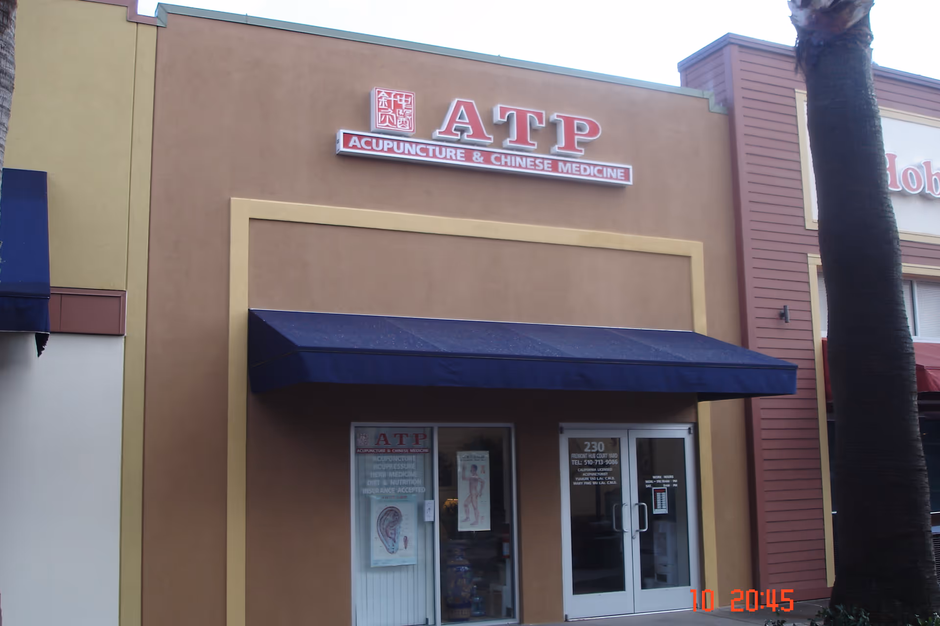 Exterior view of ATP Acupuncture & Chinese Medicine storefront with blue awning.
