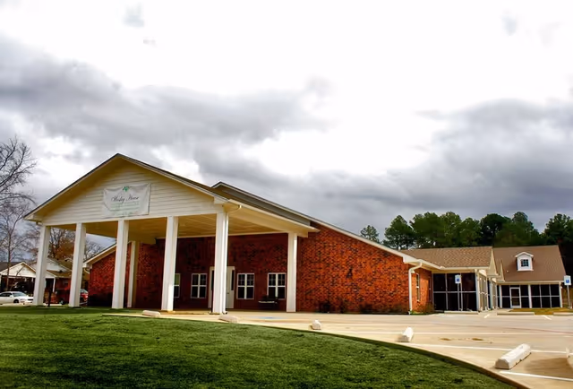 Brick Wesley House senior living facility with a white-columned entrance and covered drop-off area.