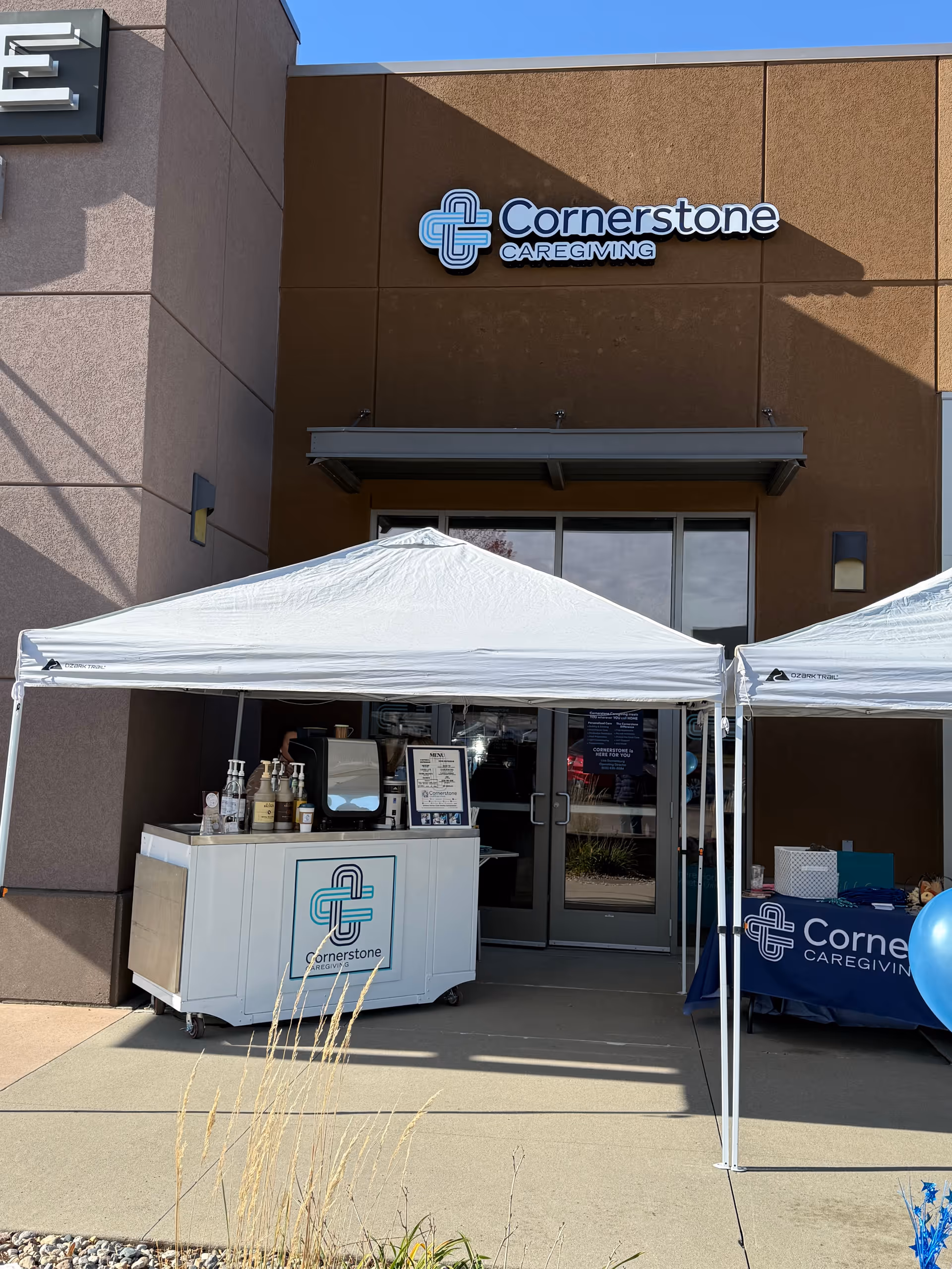 Exterior of Cornerstone Caregiving facility with white tents and beverage cart at entrance.