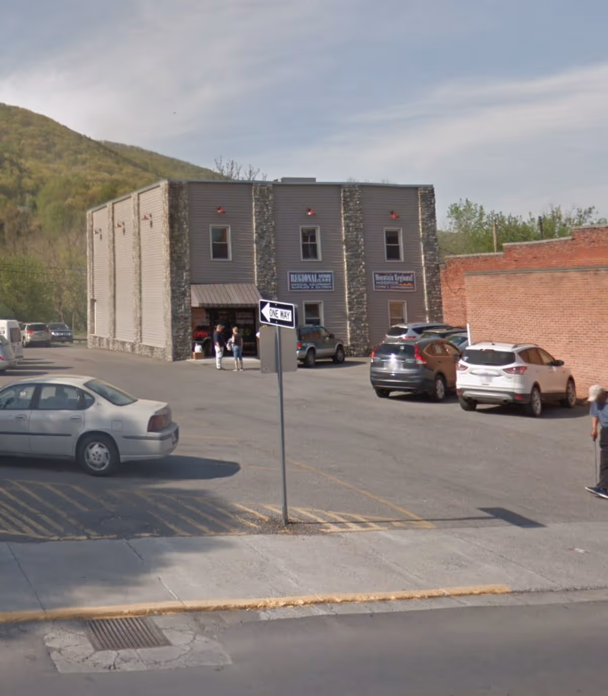 Exterior view of Mountain Regional Hospice building with parked cars near entrance