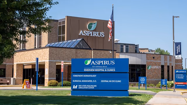 Exterior view of Aspirus facility with blue sign and American flag.