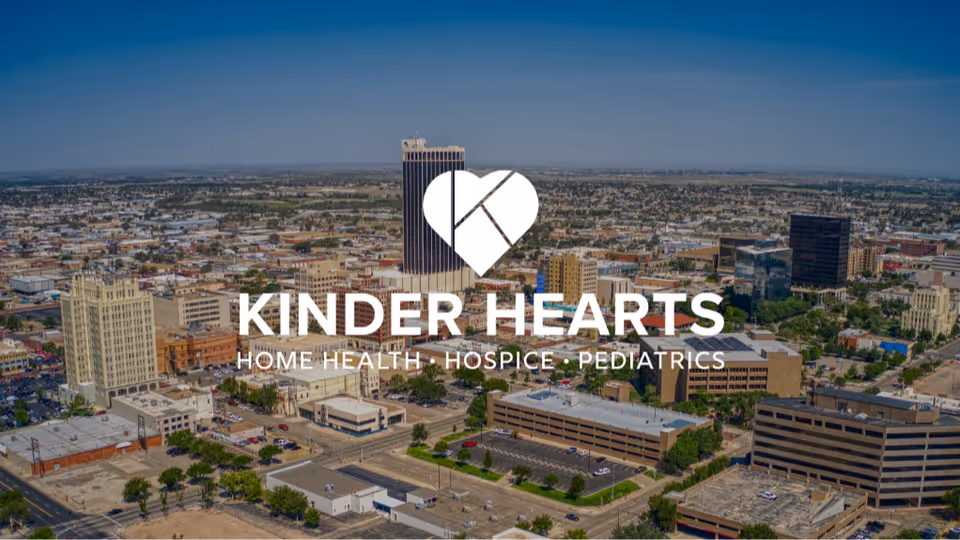 Aerial cityscape featuring a large Kinder Hearts logo and text overlay.