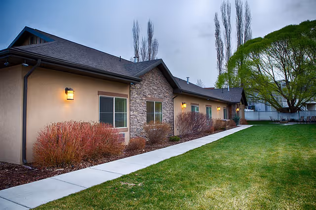 Pheasant View Assisted Living exterior with lawn, shrubs, and walkway.