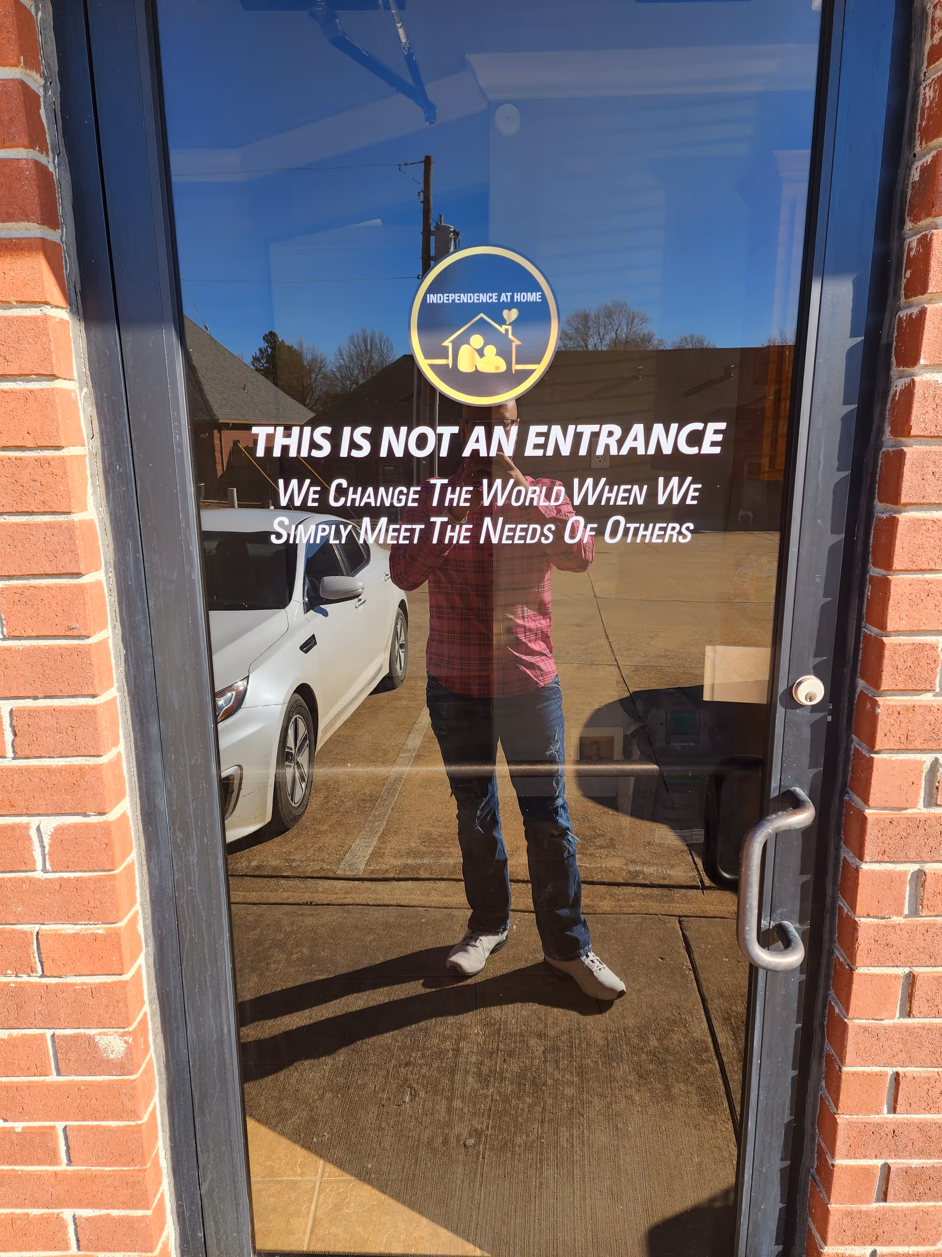 Glass door with logo reads 'This is not an entrance' with a reflection outside.
