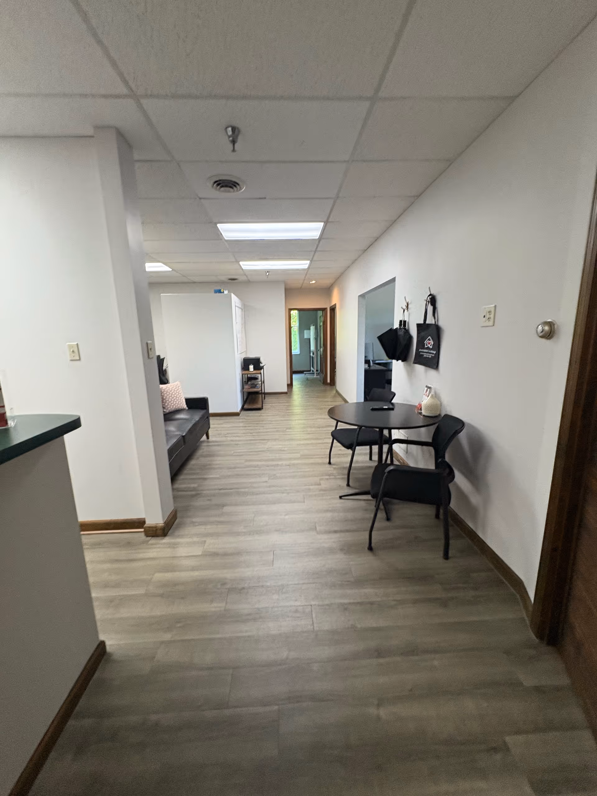 Interior hallway of a senior living facility with a small round table and seating area.