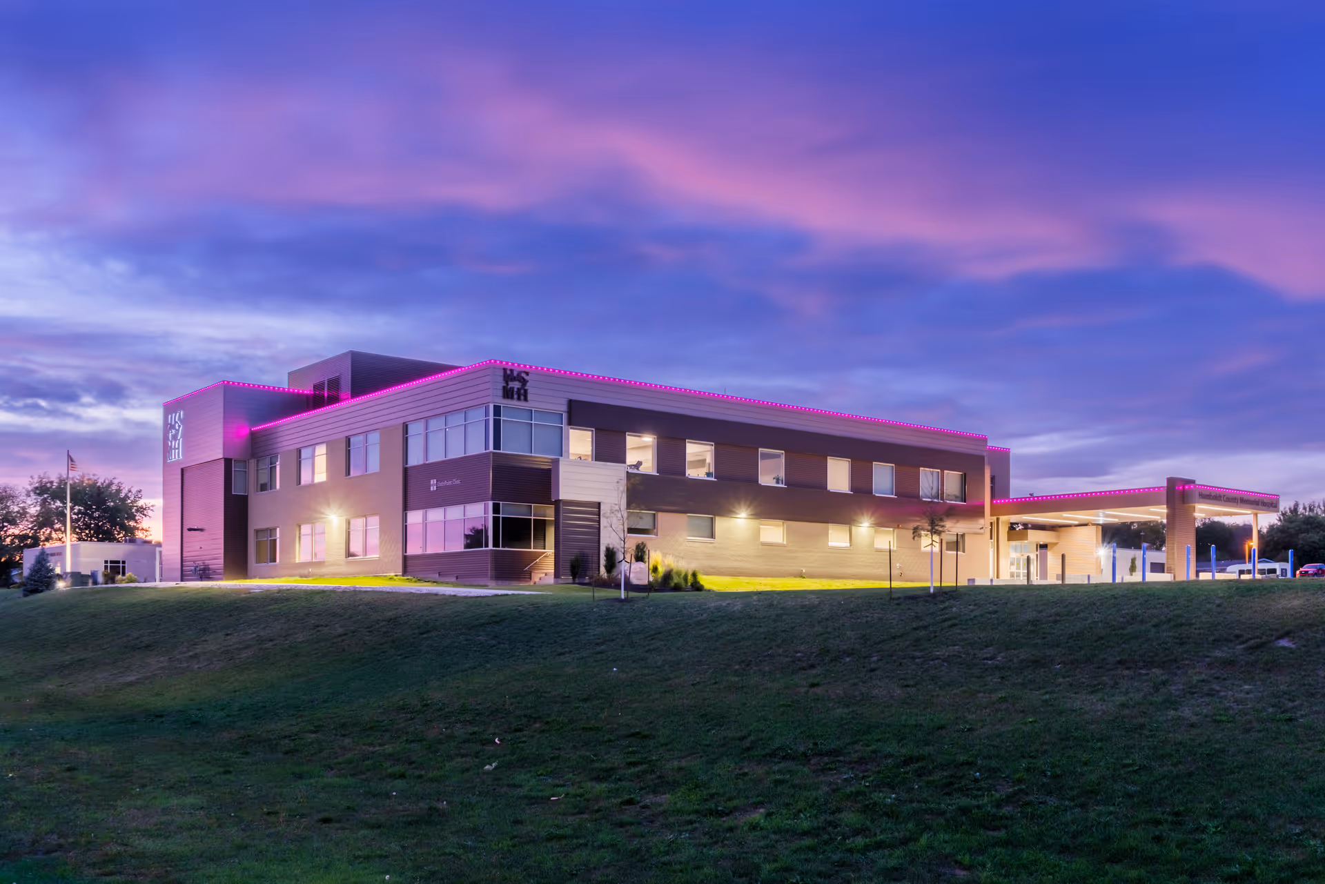 Exterior view of Humboldt County Memorial Hospital Physical Therapy building at dusk with pink lighting.