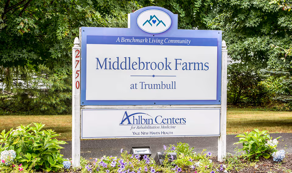 Entrance sign for Middlebrook Farms at Trumbull surrounded by landscaping and trees.